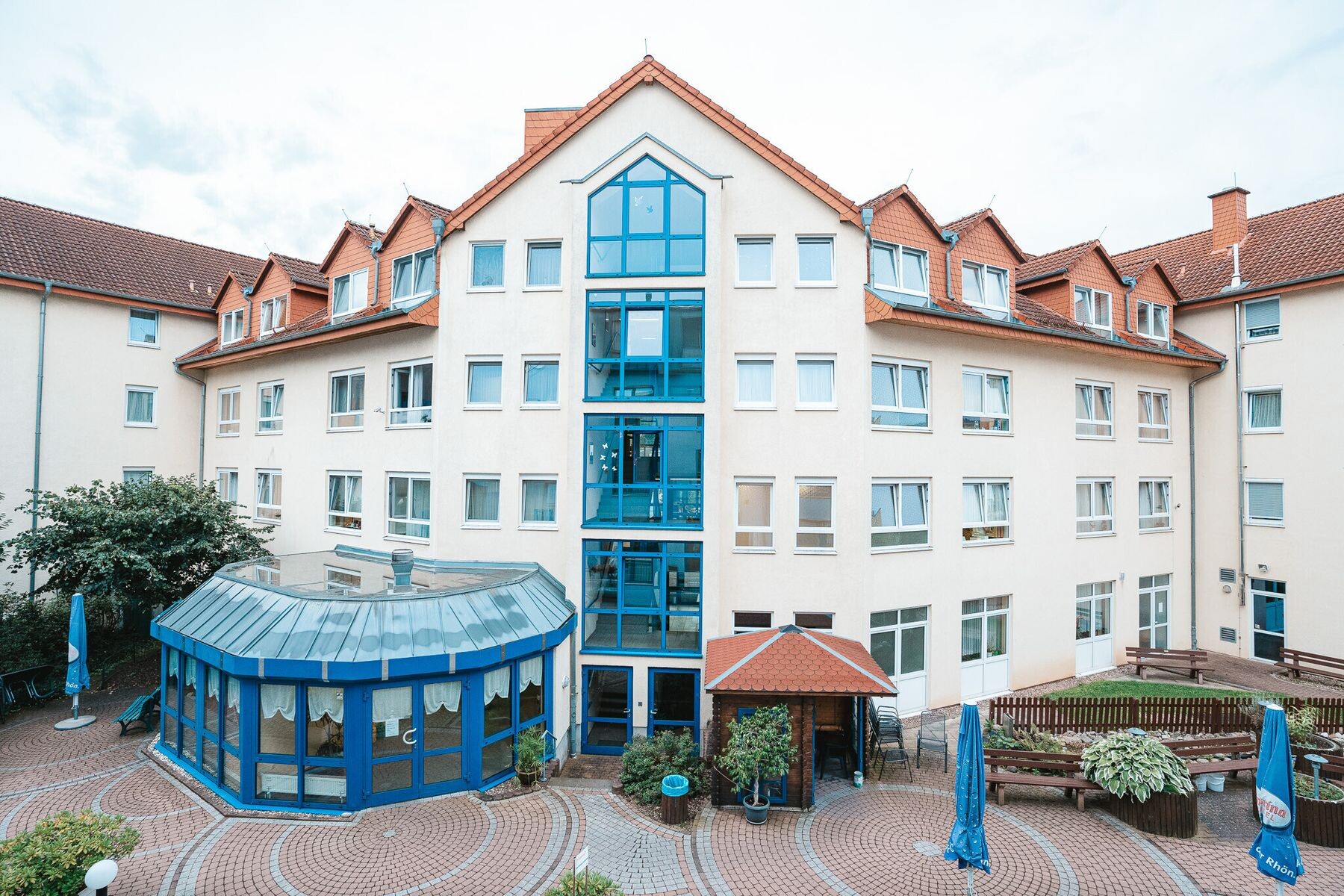 Die Anlage An den Lindengärten von oben: Gebäude mit Wintergarten, Innenhof und Sitzplätzen