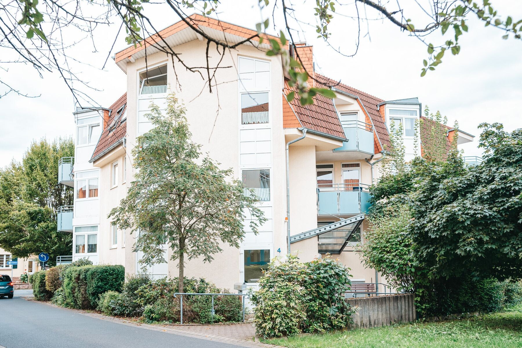 Außenansicht des Hauses An den Lindengärten mit Erkern, Balkonen und Bäumen davor